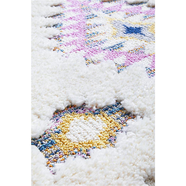 White shaggy rug with colorful tribal diamond patterns in pink, blue, and yellow tones.