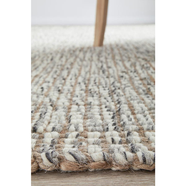 Close-up of hand-loomed Scandinavian grey wool and natural jute rug with chunky woven texture.