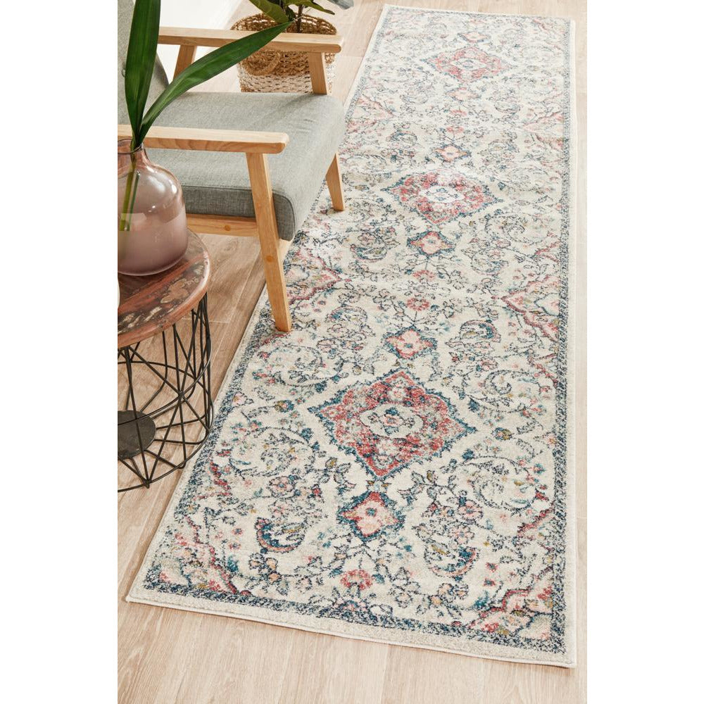 Transitional runner rug with intricate floral pattern in rose, blue, and beige on a light background.