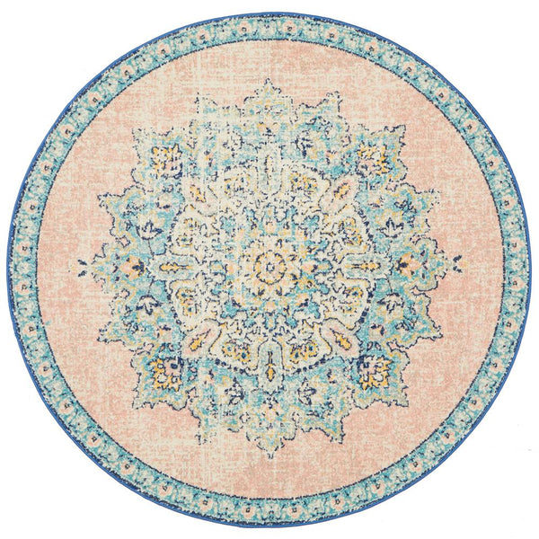 Round pastel rose rug with blue and cream intricate floral medallion pattern and blue border.