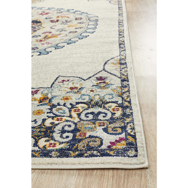 Cream rug with intricate blue, yellow, and red medallion pattern and detailed border design.
