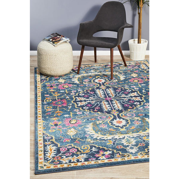 Navy blue bohemian rug with intricate pink and multicolor floral patterns and a beige border.