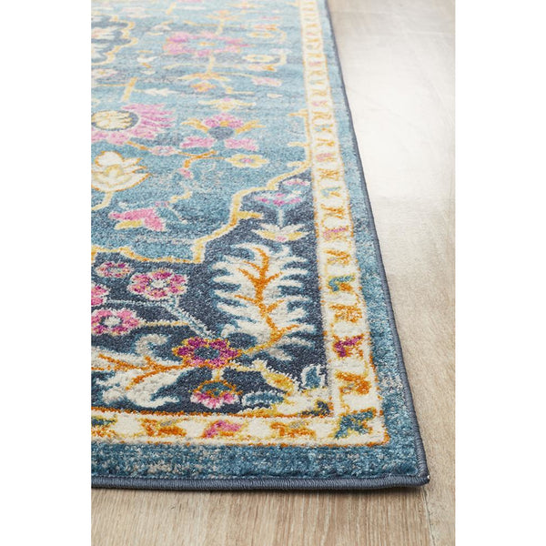 Navy blue rug with pink, yellow, and orange floral patterns and a cream border.