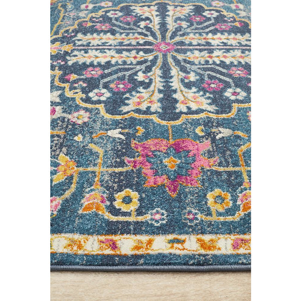 Navy blue rug with pink, yellow, and white floral and geometric bohemian patterns.