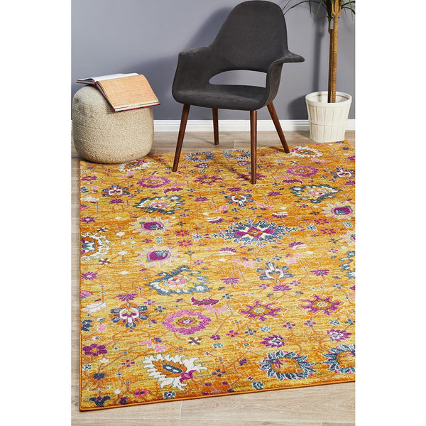 Rust pink and mustard yellow transitional rug with vibrant multicolor bohemian floral pattern.