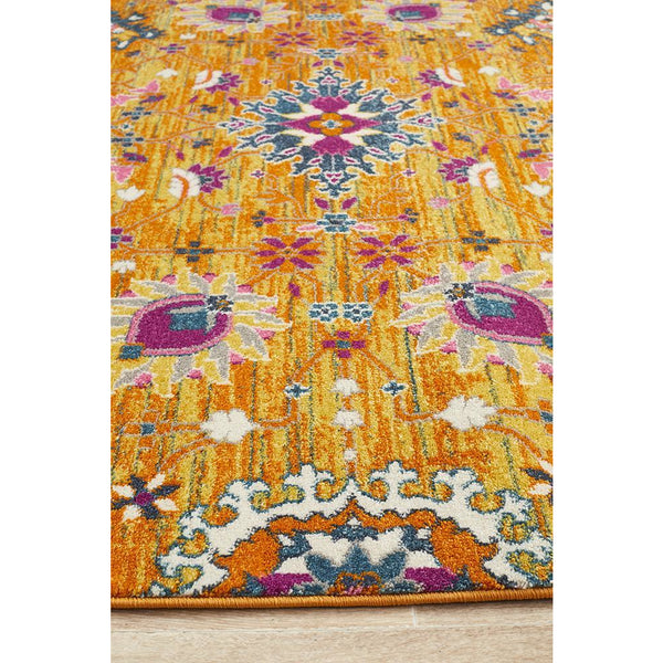 Rust pink bohemian rug with multicolor floral and geometric patterns on textured surface.