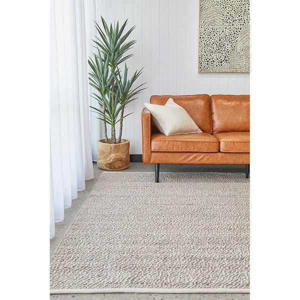 Natural-toned wool blend rug with subtle textured pattern in modern living room setting.