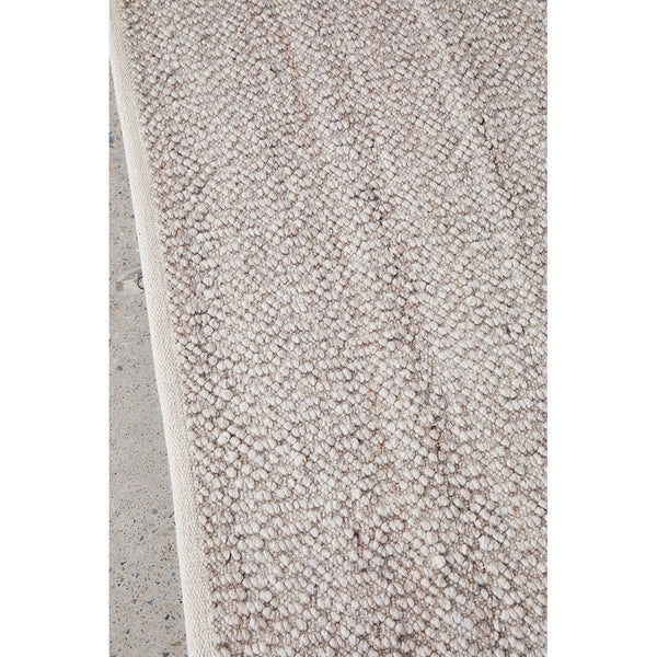 Natural light-neutral wool blend rug with subtle textured pattern and soft pile.