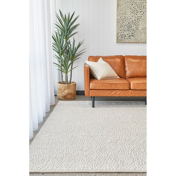 White patterned modern polyester cotton rug with boucle texture in a bright living room setting.