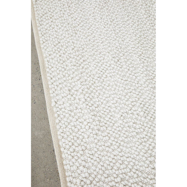 White patterned modern rug with boucle texture and subtle geometric design.