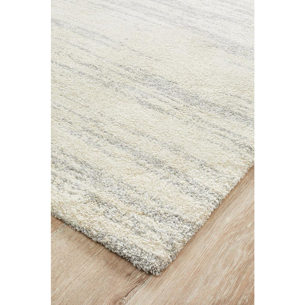 Silver grey beige plush rug with subtle geometric pattern and soft textured pile on wooden floor.