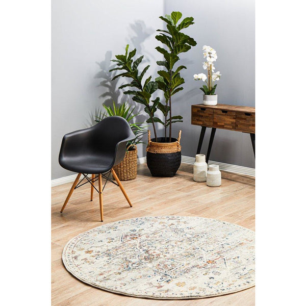 Round transitional medallion patterned rug in silver grey and muted multicolor on light wood floor.