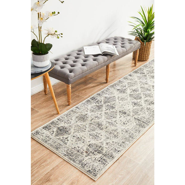 Grey multi-color diamond patterned transitional runner rug on light wood floor.