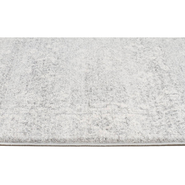 Silver grey designer rug with subtle textured pattern and low pile edge detail.