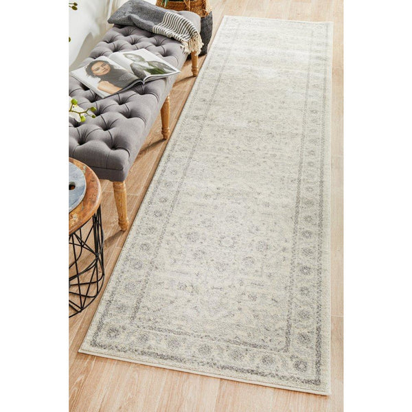 Beige and light grey patterned transitional runner rug with subtle floral motifs on wooden floor.