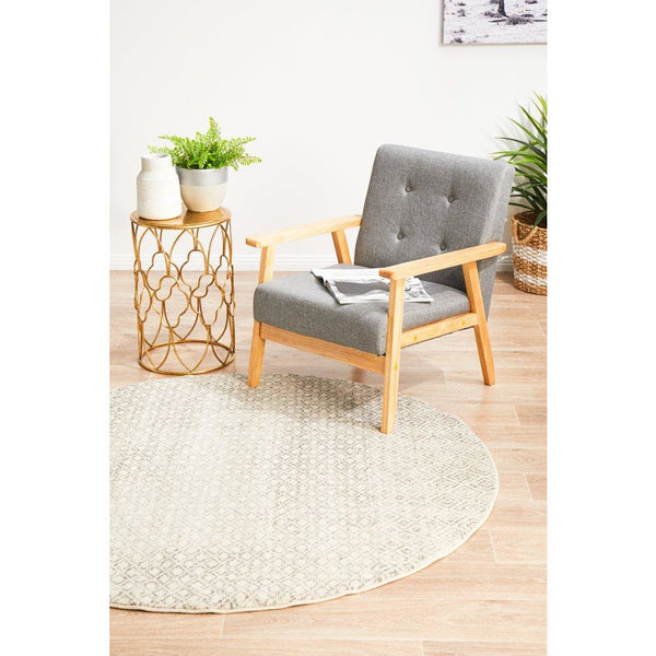 Round grey beige transitional rug with subtle textured pattern on light wood floor.