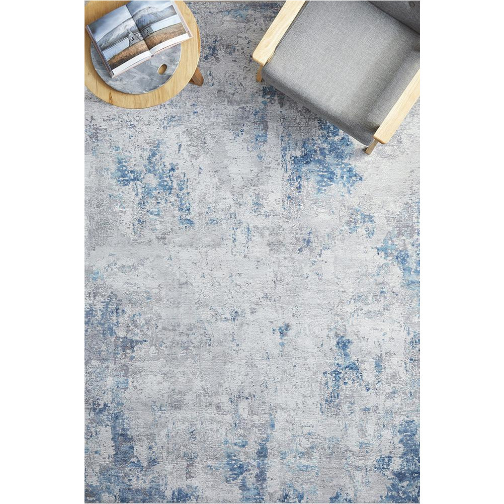 Blue, grey, and beige transitional rug with distressed abstract pattern and polyester pile.