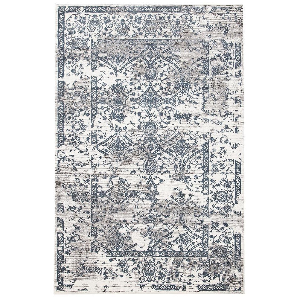 White rug with blue and grey abstract floral border pattern and distressed vintage look.
