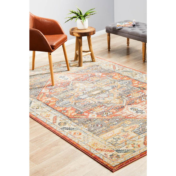 Rectangular terracotta multi-colored rug with intricate tribal patterns and a distressed border on light wood floor.