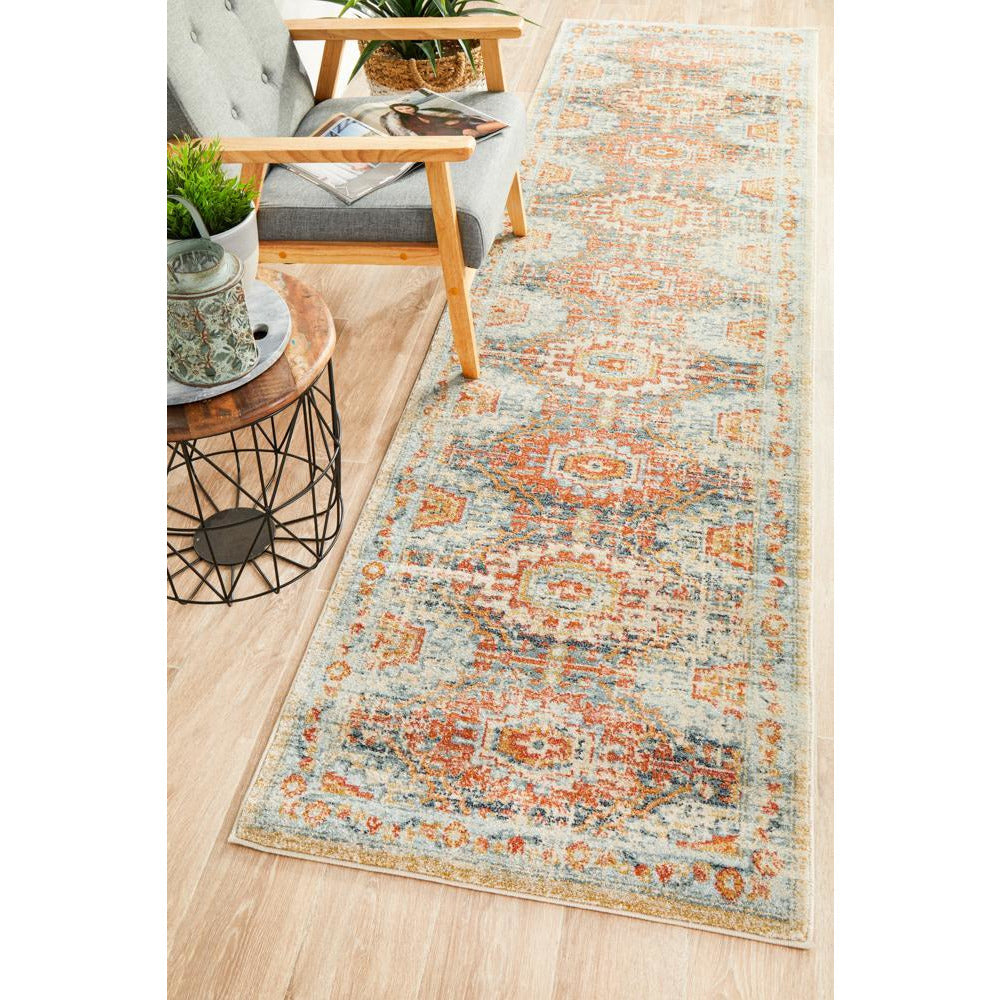 Blue and terracotta tribal patterned transitional runner rug on light wood floor.