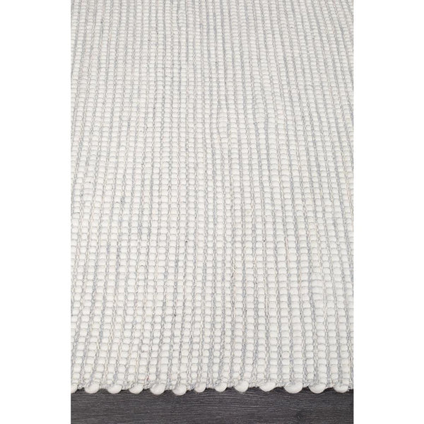 Grey chunky-knit textured wool rug with a flat-woven, hand-loomed finish.