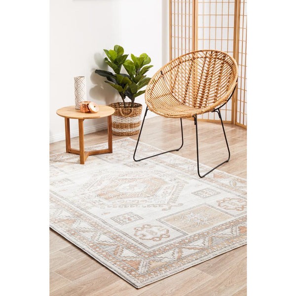 Transitional medallion patterned rug in peach, natural white, and silver tones with geometric accents.