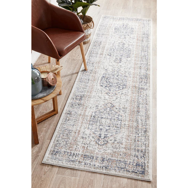 Transitional runner rug with blue and peach medallion pattern and distressed design on light background.