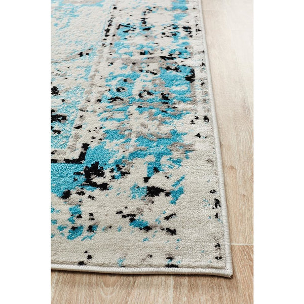Transitional abstract rug with blue, beige, and black splatter pattern on a soft polypropylene surface.