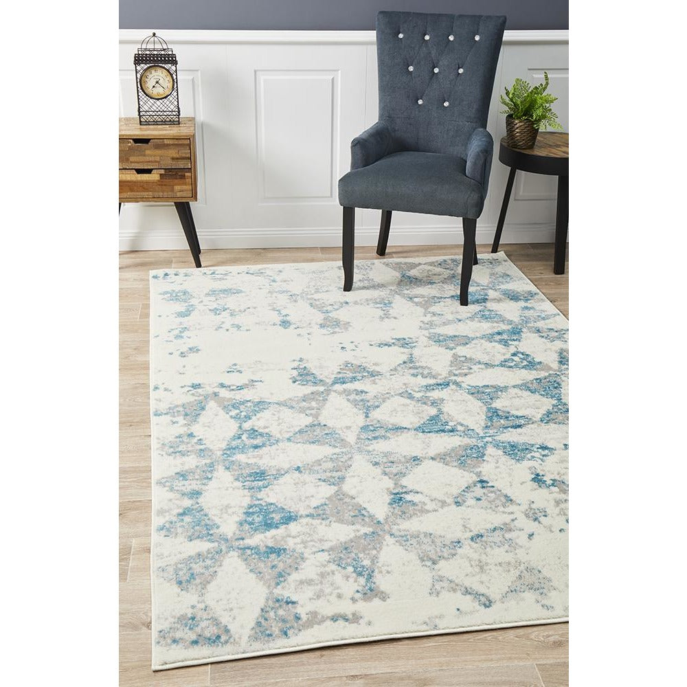 Blue, beige, and grey diamond patterned abstract rug with a soft, modern design.