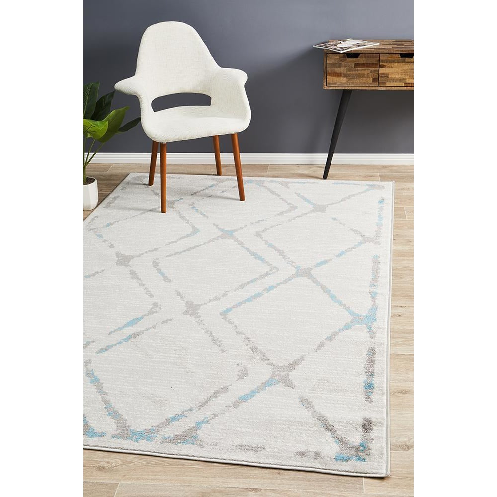 Modern diamond patterned rug in beige, blue, and grey tones with abstract design.