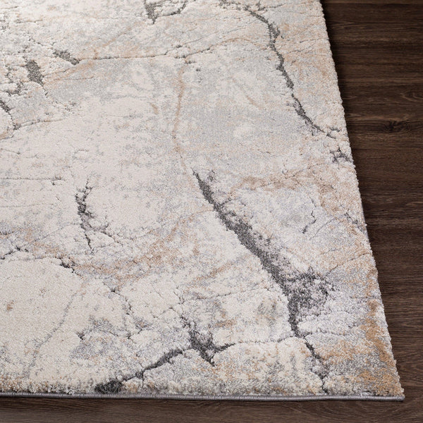 Multi-coloured abstract patterned modern rug with neutral tones and stone-inspired design on dark wood floor.