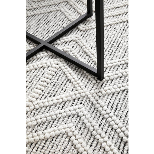 Ivory and black hand-loomed wool blend rug with textured geometric tribal pattern and raised loops.