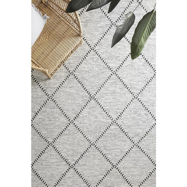Ivory wool blend rug with black trellis pattern and textured flatwoven design.