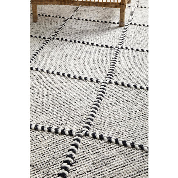 Ivory wool blend rug with black twisted trellis pattern in a flatwoven modern design.