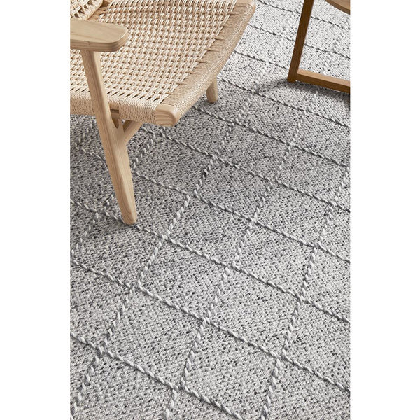 Light grey wool blend rug with subtle geometric diamond pattern and textured flatwoven design.