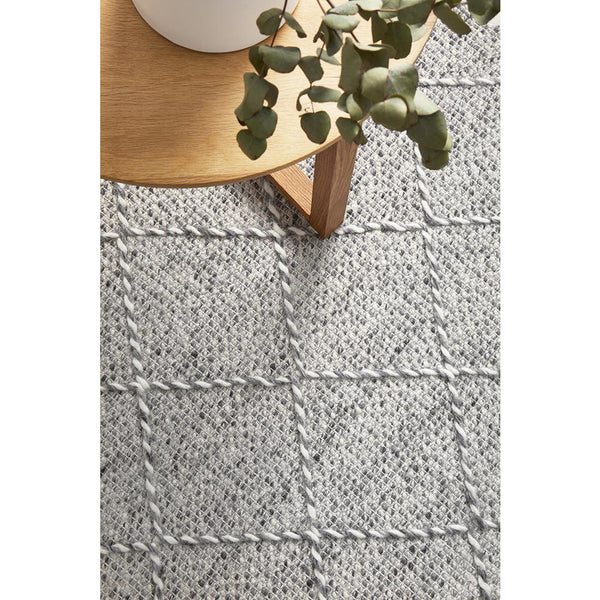 Grey and ivory hand loomed wool blend rug with subtle geometric grid pattern.