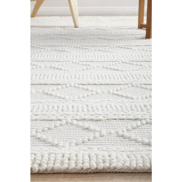 Ivory hand-loomed wool blend rug with textured geometric tribal pattern and soft pile.