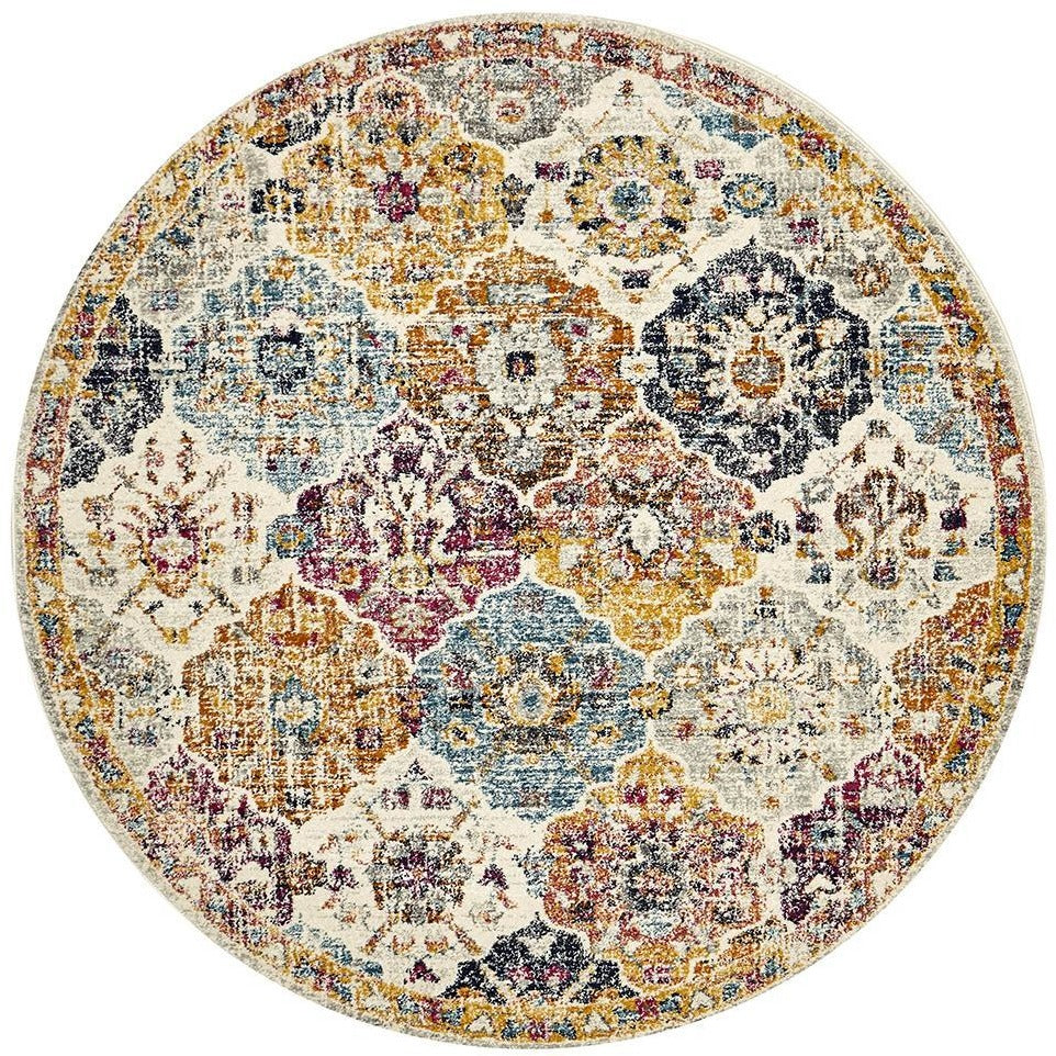 Round transitional bohemian rug with multi-colored circular and floral patterns in mustard, navy, blue, and burgundy on a.
