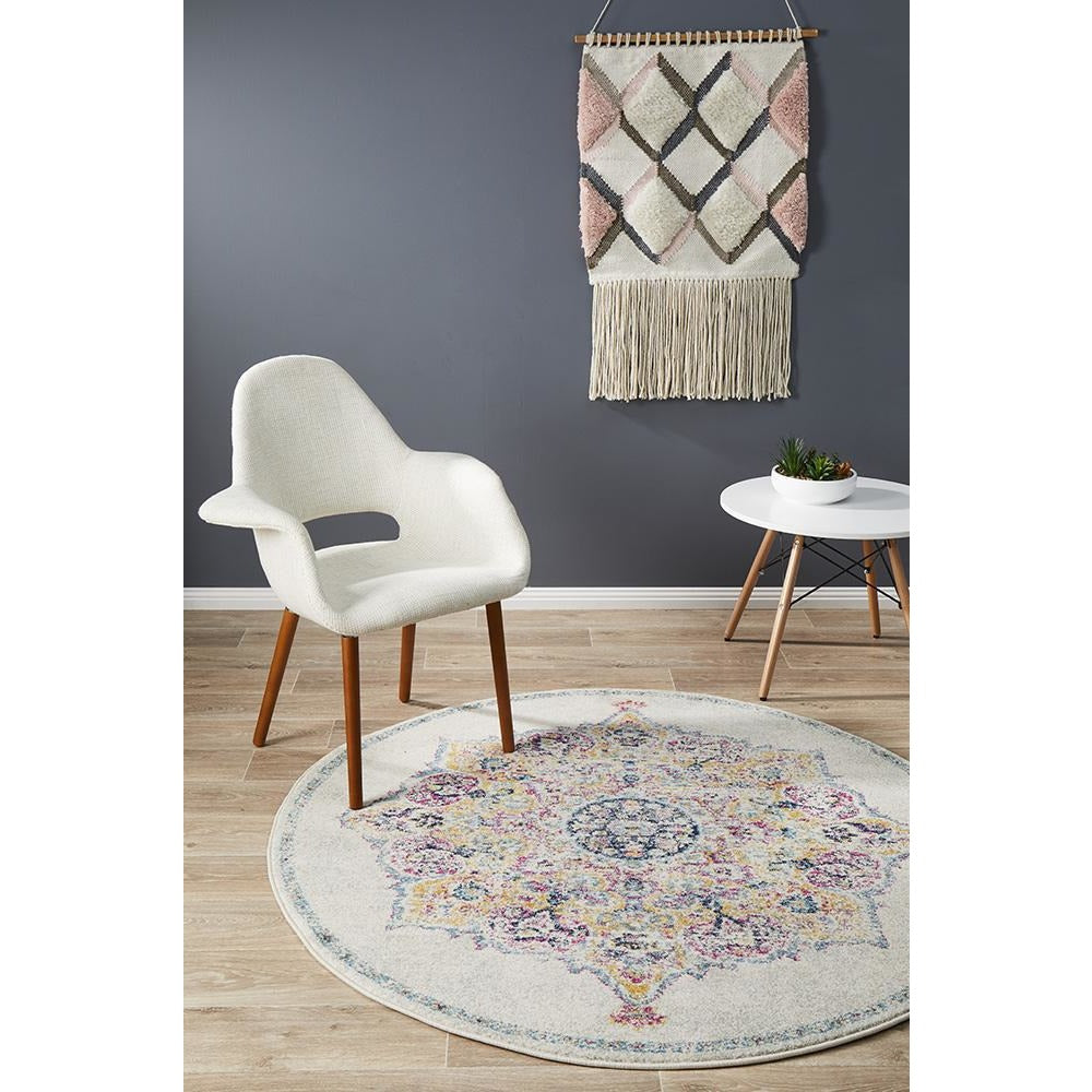 Round bohemian rug with multicolored intricate pattern on light bone background.
