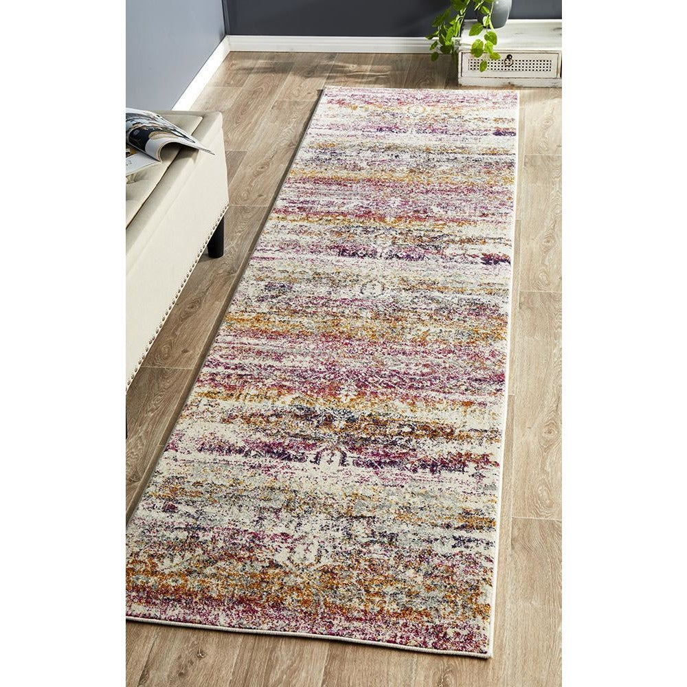 Transitional bohemian runner rug with fuchsia, purple, beige, and gold multi-colored abstract pattern on polypropylene fibers.