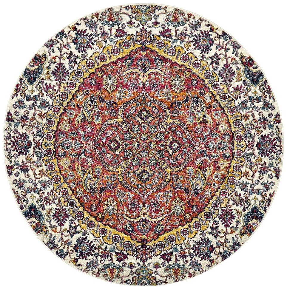 Round bohemian rug with rust, beige, purple, and mustard intricate floral patterns on a white background.