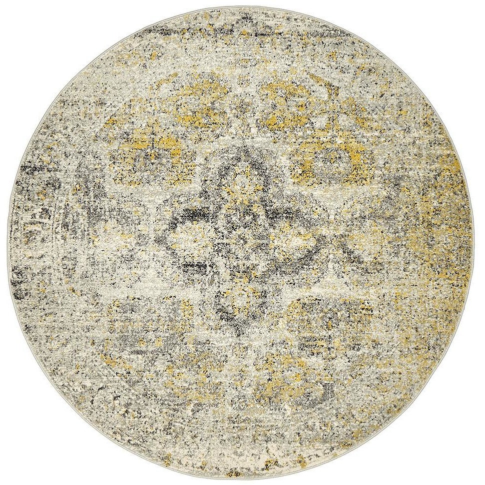 Round silver grey bohemian rug with distressed yellow and charcoal pattern.