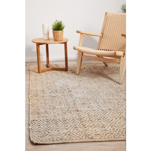 Rectangle natural jute rug with white diamond hand-braided pattern in a coastal style room setting.