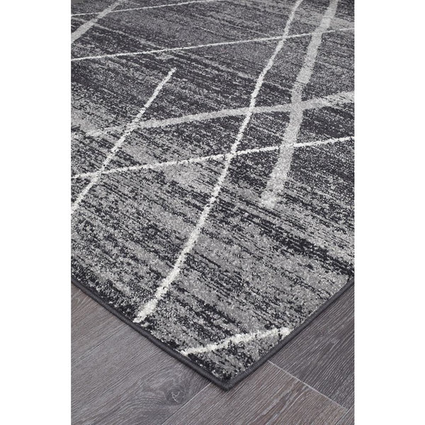 Charcoal grey boho rug with white tribal lattice pattern on textured polypropylene surface.