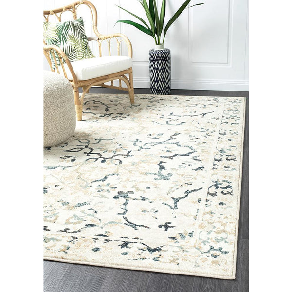 Beige and bone traditional rug with faded multicoloured floral and vine pattern on hardwood floor.