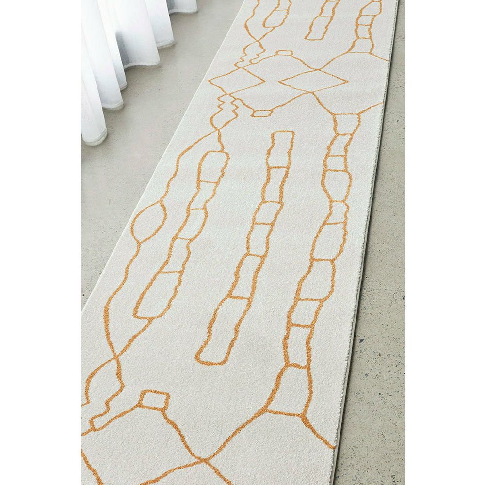 Beige runner rug with gold geometric chain-link pattern, flatwoven polypropylene texture.