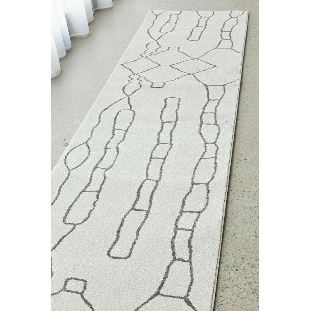 Grey modern runner rug with abstract linear pattern on soft textured surface.