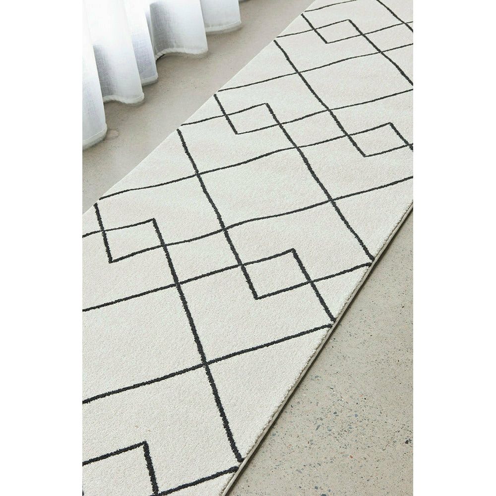Cream runner rug with black geometric line patterns on a smooth, low-pile surface.