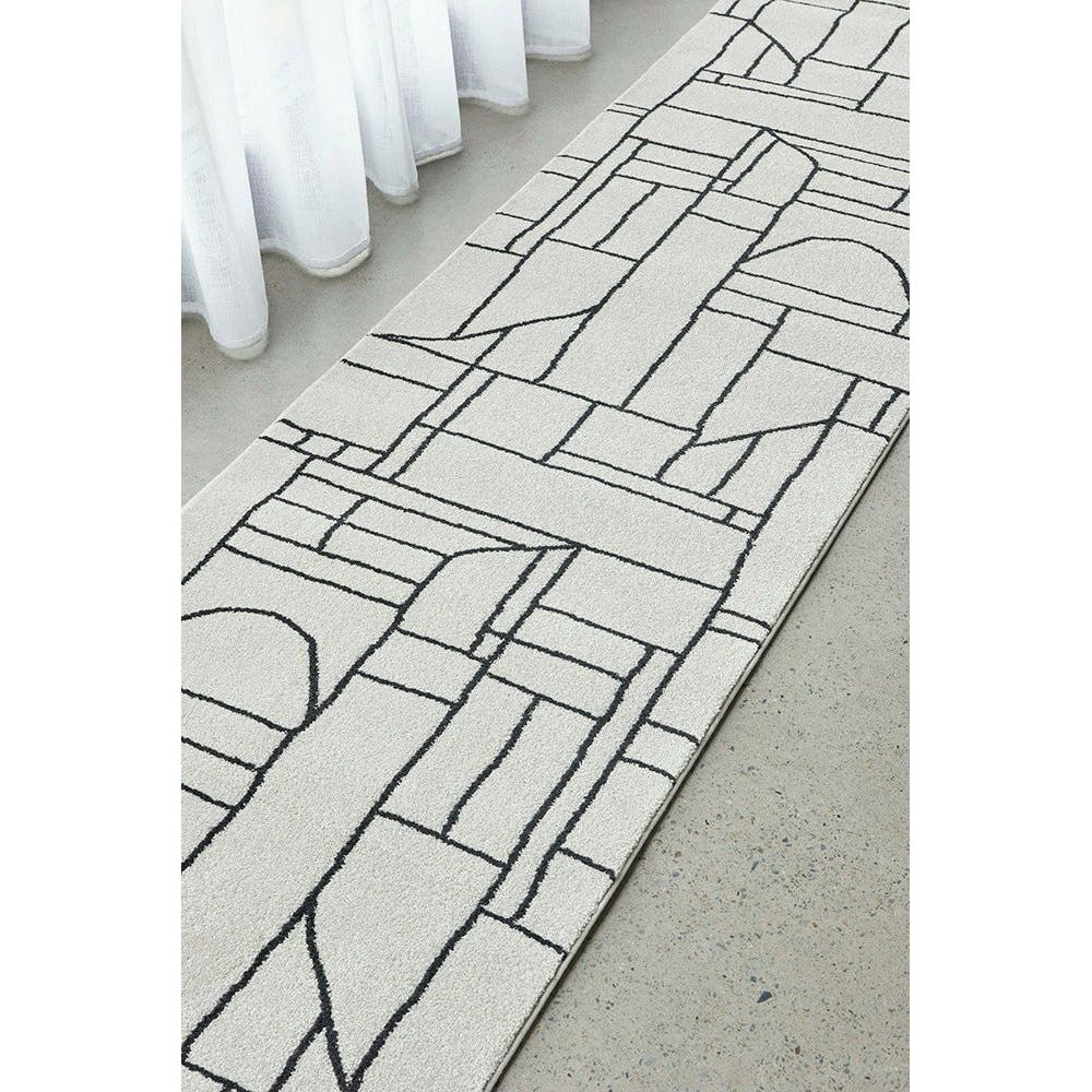 Cream runner rug with black abstract geometric pattern, low-pile modern design.