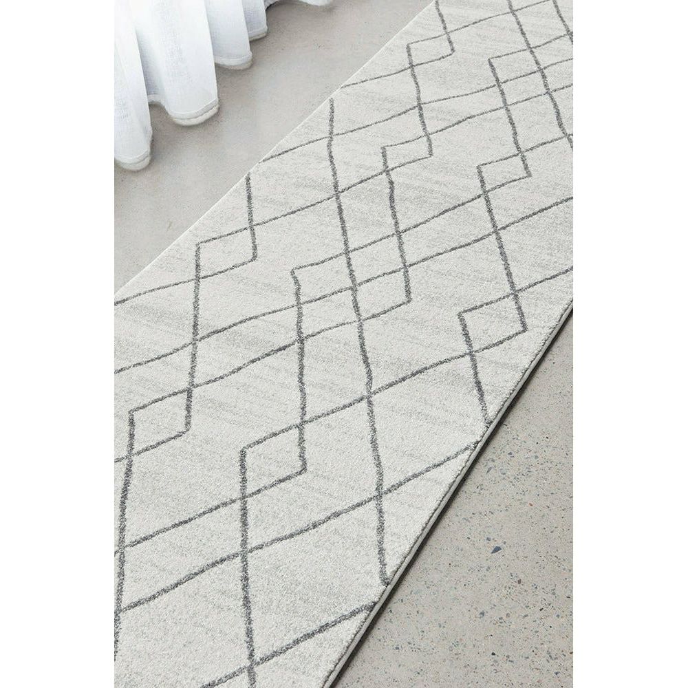 Off-white runner rug with subtle grey geometric tribal lines on a flat weave texture.